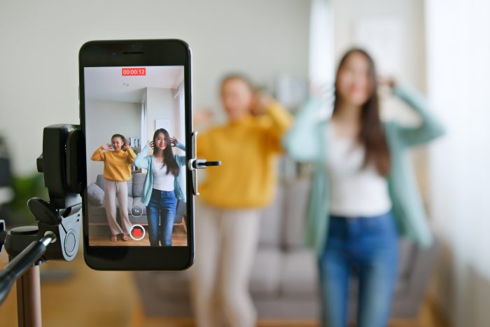 une jeune femme avec son ami tiktoker a créé ensemble sa vidéo de danse par caméra de smartphone. Pour partager une vidéo sur l'application TikTok - Comment identifier les tendances sur TikTok
